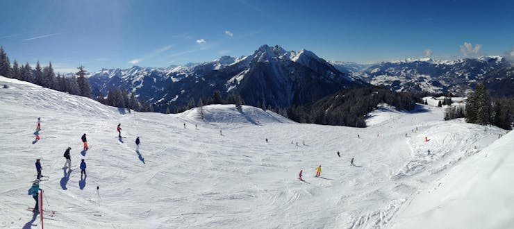 Skiërs genieten van hun skilessen op de pistes van St. Johann-Alpendorf.