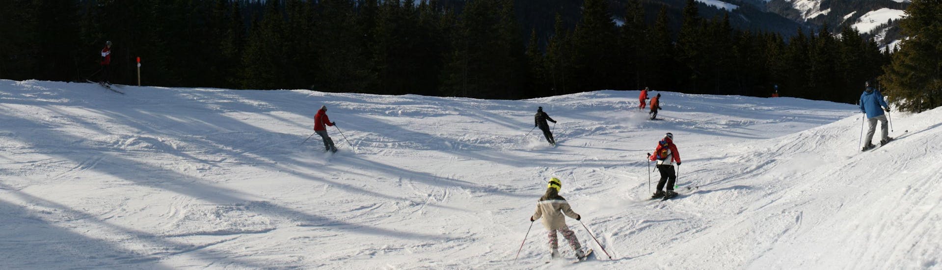 Mehrere Skifahrer genießen die einwandfreien Bedingungen auf der Skipiste im Skigebiet Stuhleck, wo örtliche Skischulen eine Reihe an Skikursen anbietet.