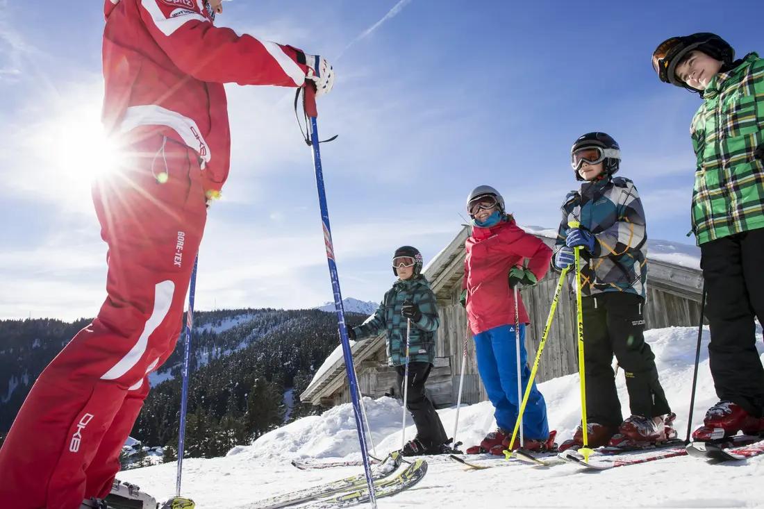 Un groupe de cinq personnes fait une pause pendant un cours de ski avec l’école de ski Sunshine.