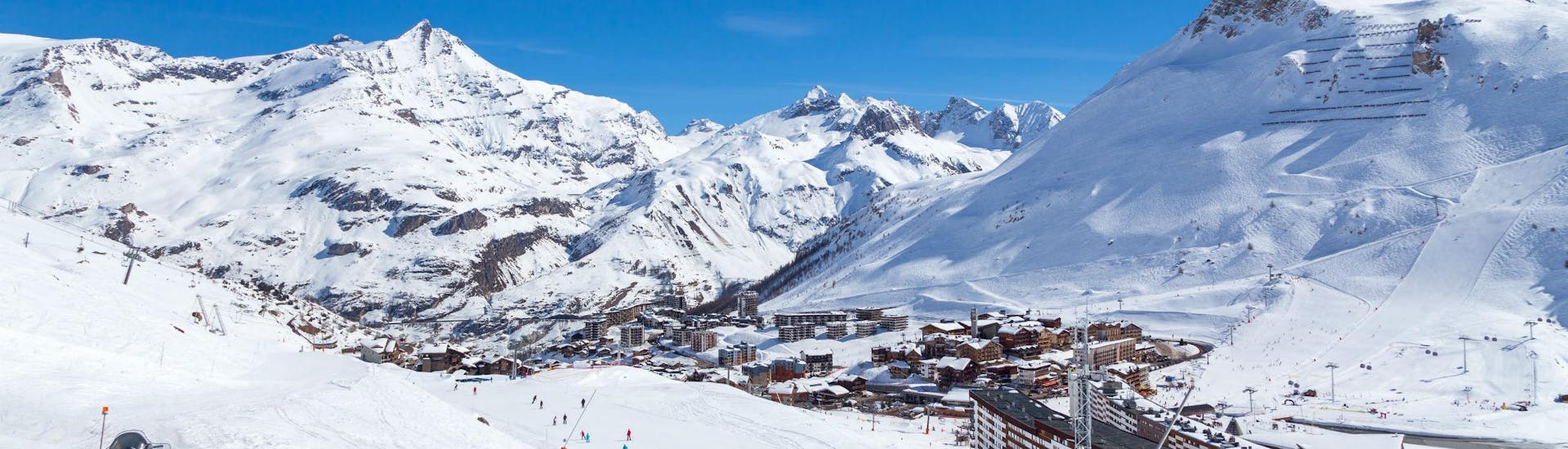 A view of the French ski resort of Tignes under the clear blue sky with its many pistes used by the local ski schools to carry out their ski lessons.