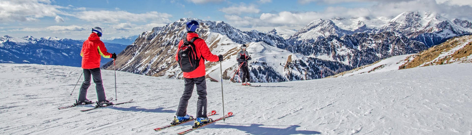 Skiers are enjoying the stunning panorama of Val di Fiemme in the ski area Dolomiti Superski  in Trentino, where local ski schools offer their ski lessons.