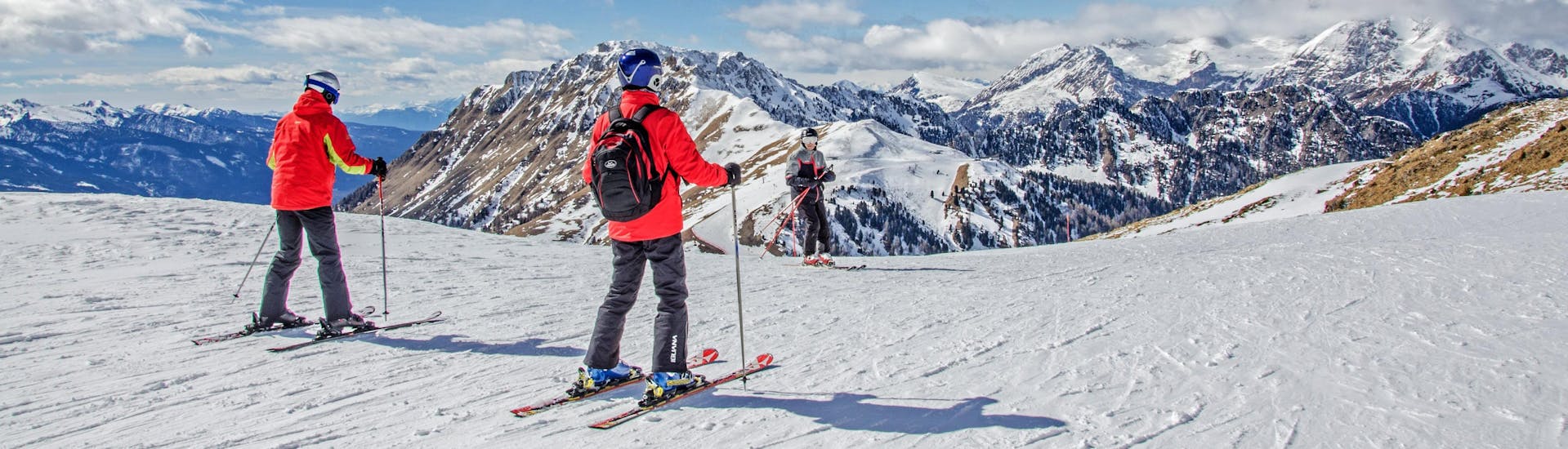 Skiers are enjoying the stunning panorama of Val di Fiemme, where local ski schools offer their ski lessons.