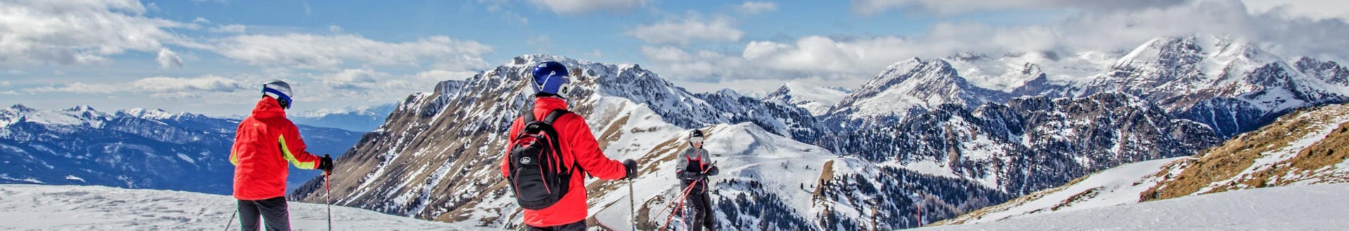 Skifahrer genießen das atemberaubende Panorama des Val di Fiemme, wo die örtlichen Skischulen ihre Skikurse anbieten.