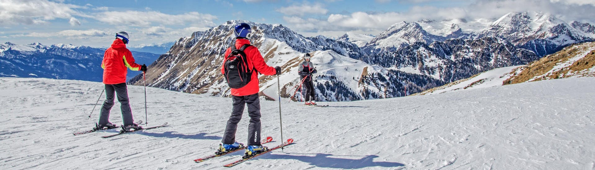 Skifahrer genießen das atemberaubende Panorama des Val di Fiemme, wo die örtlichen Skischulen ihre Skikurse anbieten.