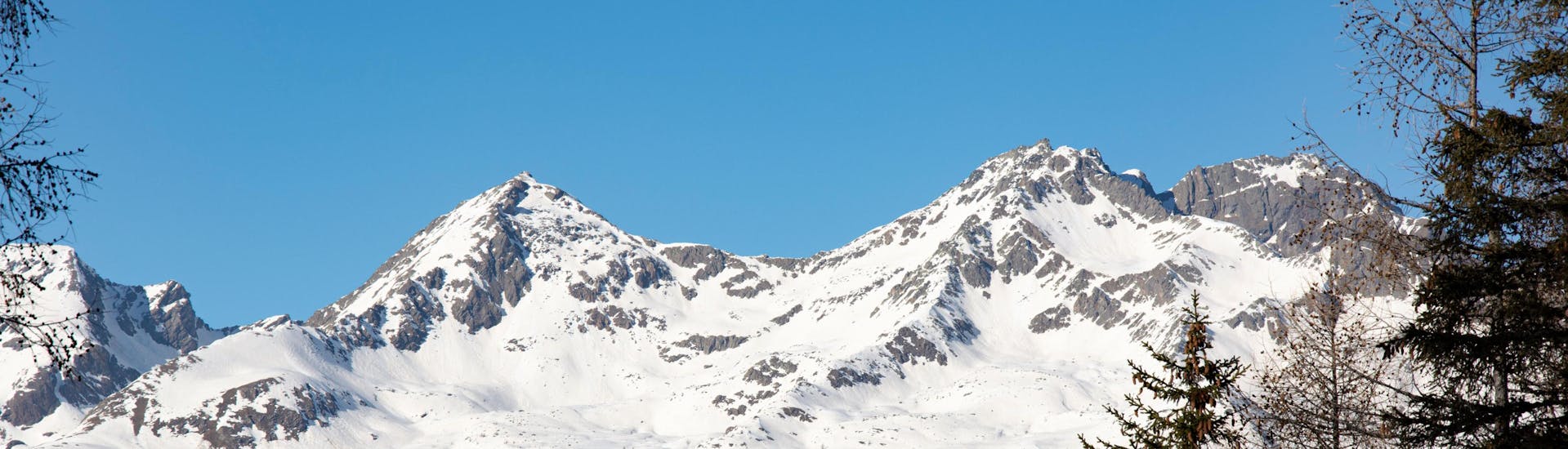 Winterliche Landschaft der Pisten von Val di Sole, wo man Skikurse buchen kann.