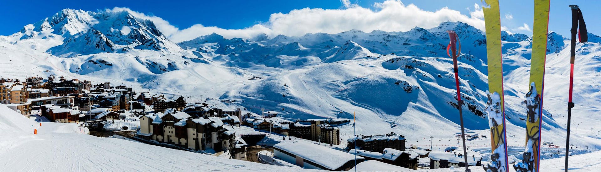 Une paire de skis plantée dans la neige sur l'une des pistes de Val Thorens, une station de ski française où les écoles de ski locales proposent différents cours de ski à ceux qui souhaitent apprendre à skier.