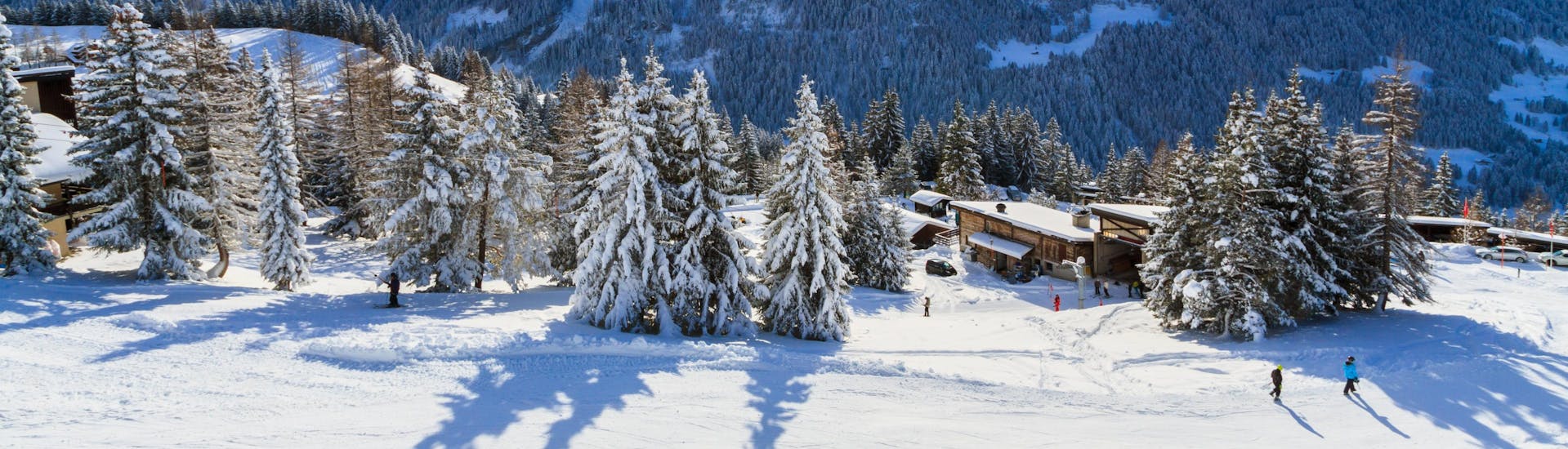 Ein Panoramablick auf die Skipisten und die umliegenden Berge von Villars-Bretaye, einem beliebten schweizer Skigebiet, in dem Besucher bei einer der örtlichen Skischulen einen Skikurs buchen können.