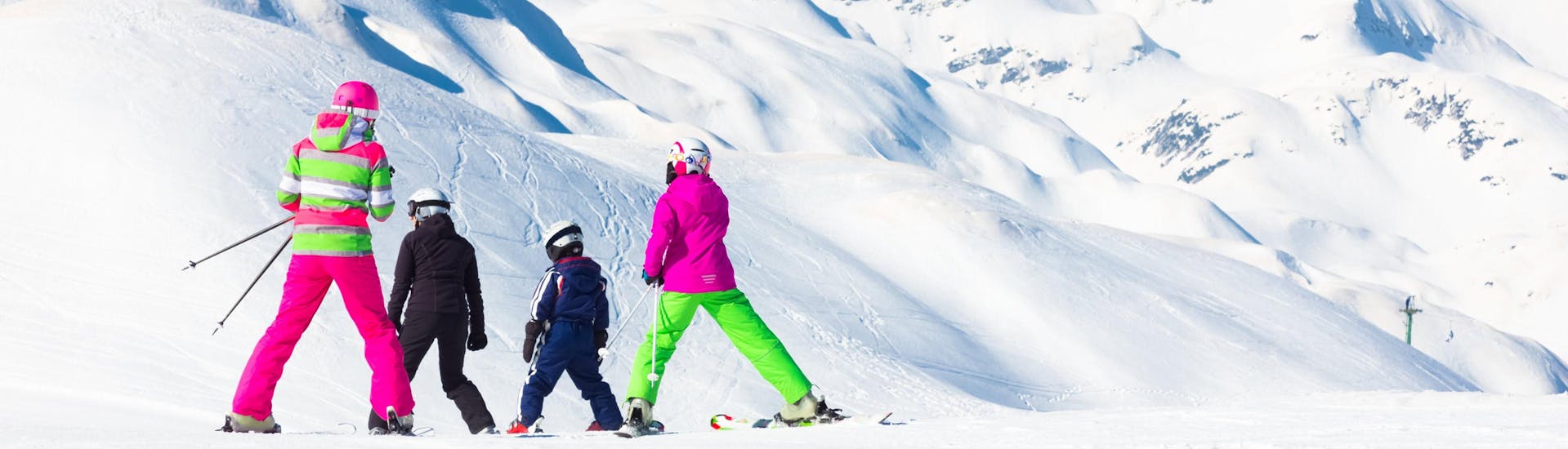 Eine Familie fährt die Pisten des Vogel Ski Center in Slowenien hinunter, wo die örtlichen Skischulen ihre Skikurse anbieten.