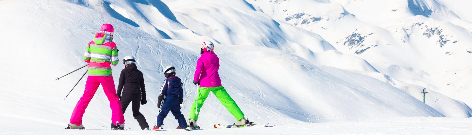 Eine Familie fährt die Pisten des Vogel Ski Center in Slowenien hinunter, wo die örtlichen Skischulen ihre Skikurse anbieten.