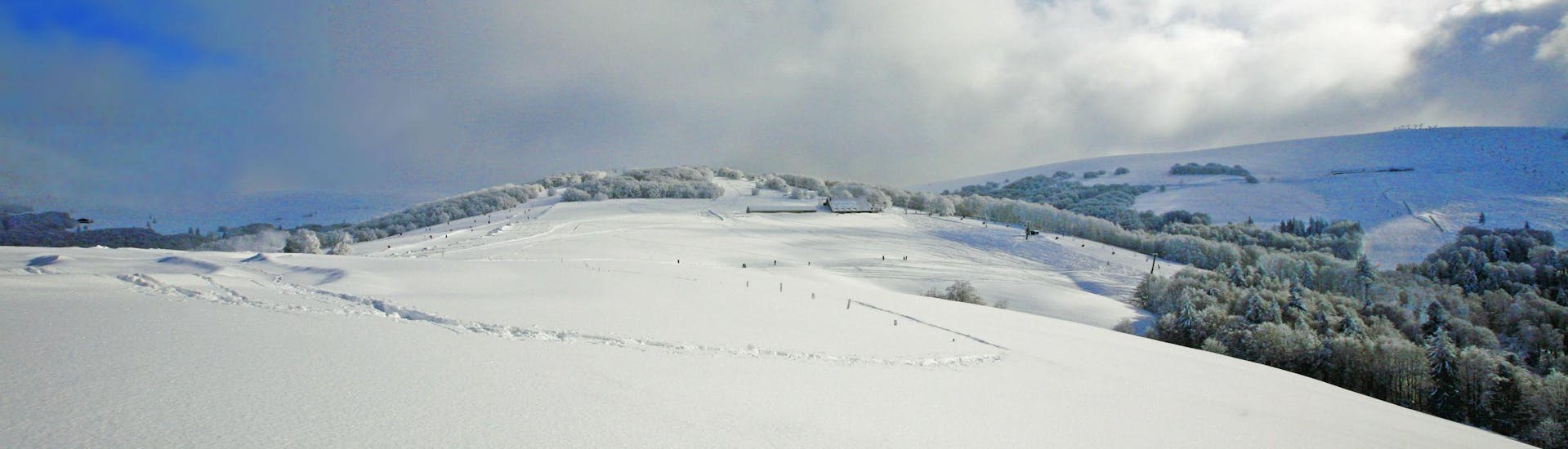 An image of the snow-covered hills in the French department of Vosges, where local ski schools offer a selection of ski lessons.