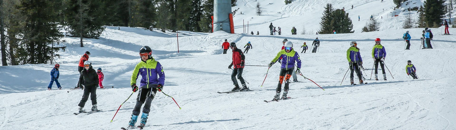 Adulti e bambini che sciano nella stazione sciistica di Kreishberg.