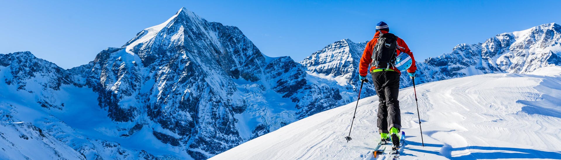 Ein Mann erkundet bei seiner Skitour in Ski Arlberg die verschneite Berglandschaft.