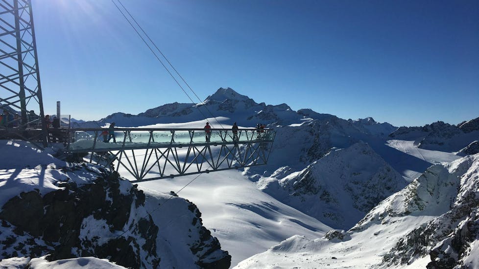 Eine Gruppe von Skifahrern, die mit der Ski- und Snowboardschule SNOWLINES Sölden das Skifahren lernt, genießt den Ausblick von der Aussichtsplattform in Sölden.
