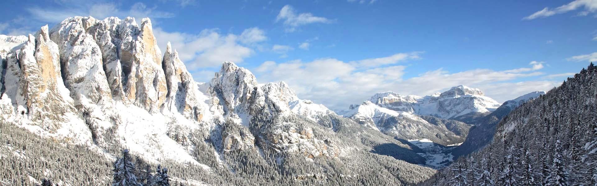 skiarea-small:hero Panorama mozzafiato con montagne e mare, dove hanno luogo le attività di Scuola di Sci Vigo di Fassa.