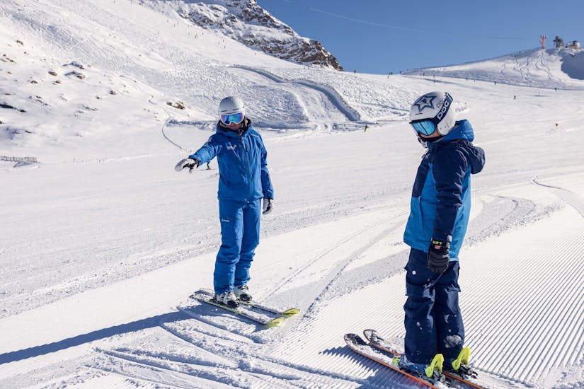 A child takes a private kids ski lessons for all levels at the Skipower Finkenberg ski school and practices in the snow with their instructor. 