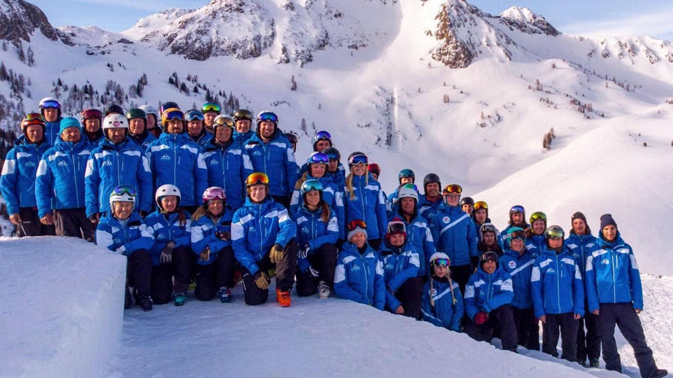 The ski instructors from the ski school Skischule Fieberbrunn Widmann Mountain Sports are collectively posing for a group photo in the Tyrolean ski resort of Fieberbrunn.
