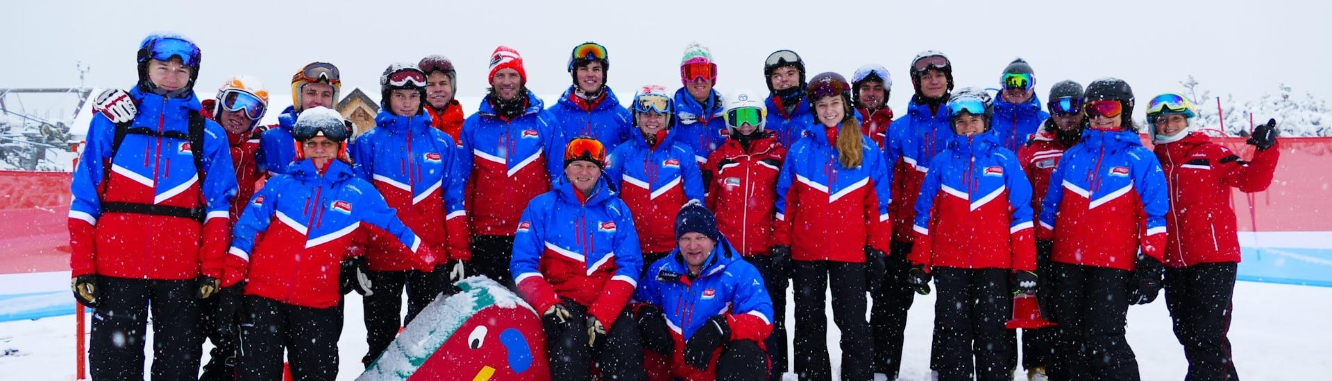 The ski instructors of Skischule Klostertal are smiling into the camera while they are taking a picture.