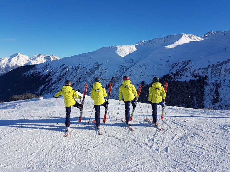 The ski instructors of Skischule Monntains are posing for a photo in the beautiful mountain scenery of Sedrun.