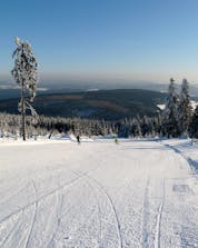 Ein Blick über die verzaubernde Winterlandschaft in Fichtelberg-Oberwiesenthal, einem deutschen Skigebiet in dem örtliche Skischulen ihre Skikurse für alle die das Skifahren lernen wollen anbieten.