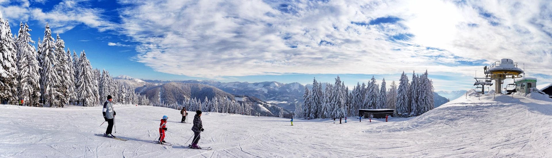 Ausblick auf die sonnige Berglandschaft beim Skifahren lernen mit den Skischulen im Skigebiet Mariazell - Bürgeralpe.