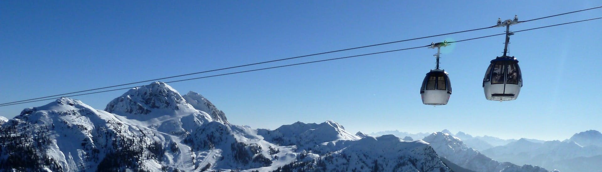 View over the sunny mountain landscape while learning to ski with the ski schools in Nassfeld-Pressegger See.