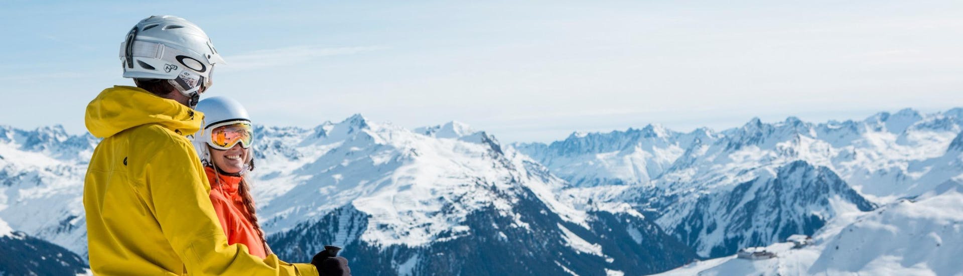 Ein Mann und eine Frau blicken bei ihrem Skikurs mit einer der örtlichen Skischulen über das traumhafte Bergpanorama des Montafons in Vorarlberg.