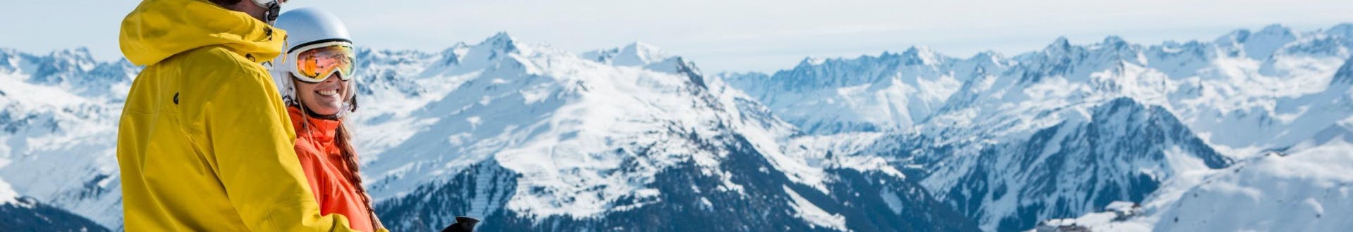 Ein Mann und eine Frau blicken bei ihrem Skikurs mit einer der örtlichen Skischulen über das traumhafte Bergpanorama im Montafon.