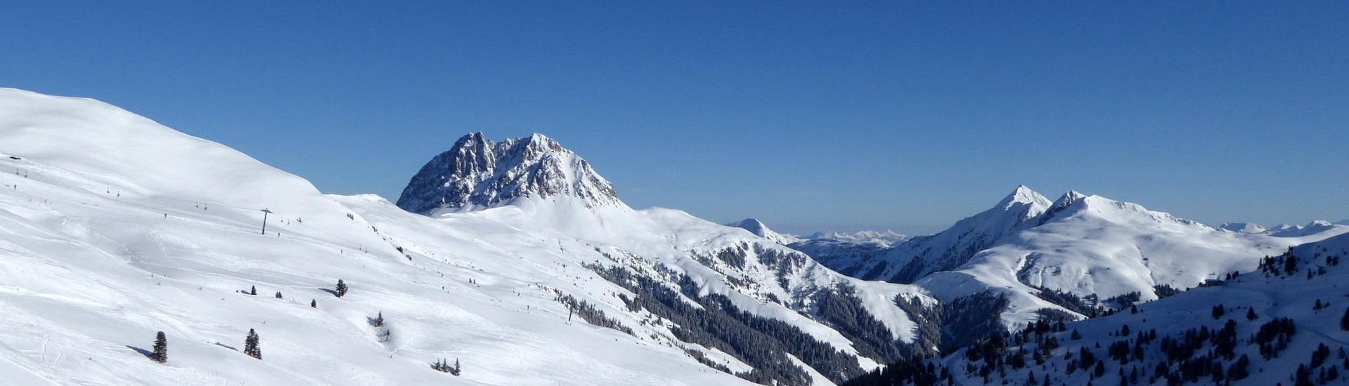 View over the sunny mountain landscape while learning to ski with the ski schools in the Wildkogel Arena.