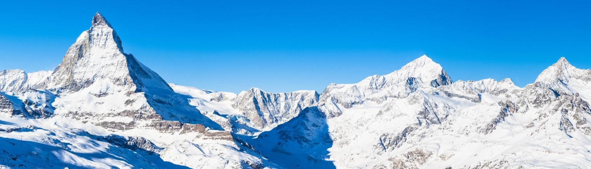 Vista del paesaggio montano soleggiato durante un corso di sci con scuole di sci a Zermatt.