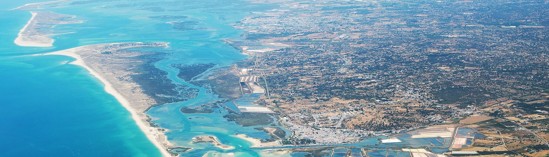 Paracaidistas disfrutando de su salto en paracaídas mientras sobrevuelan Algarve, uno de los sitios más populares para tirarse en paracaídas. 