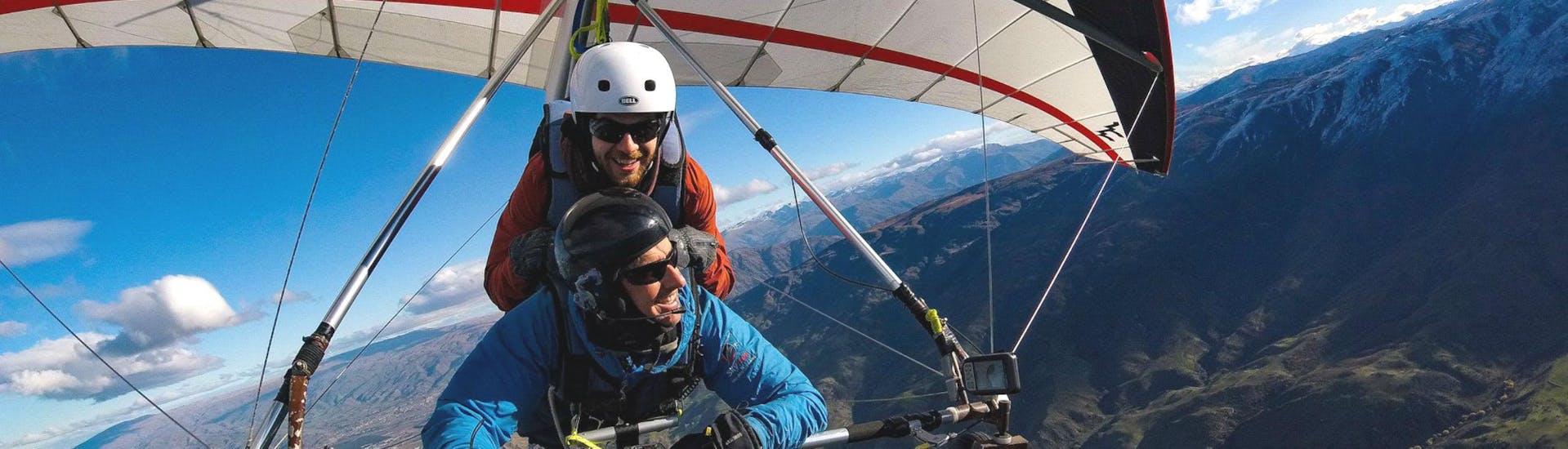 A hang gliding instructor from Skytrek Queenstown and his passenger are enjoying a scenic flight over the beautiful landscape close to Queenstown, New Zealand.