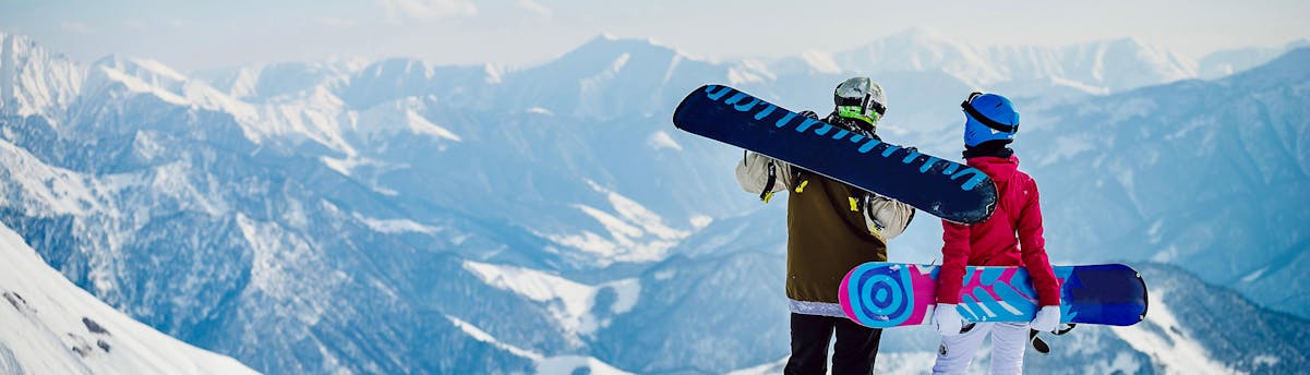 Snowboard Schools and Lessons SEM Een paar snowboarders staat en kijkt naar de horizon.