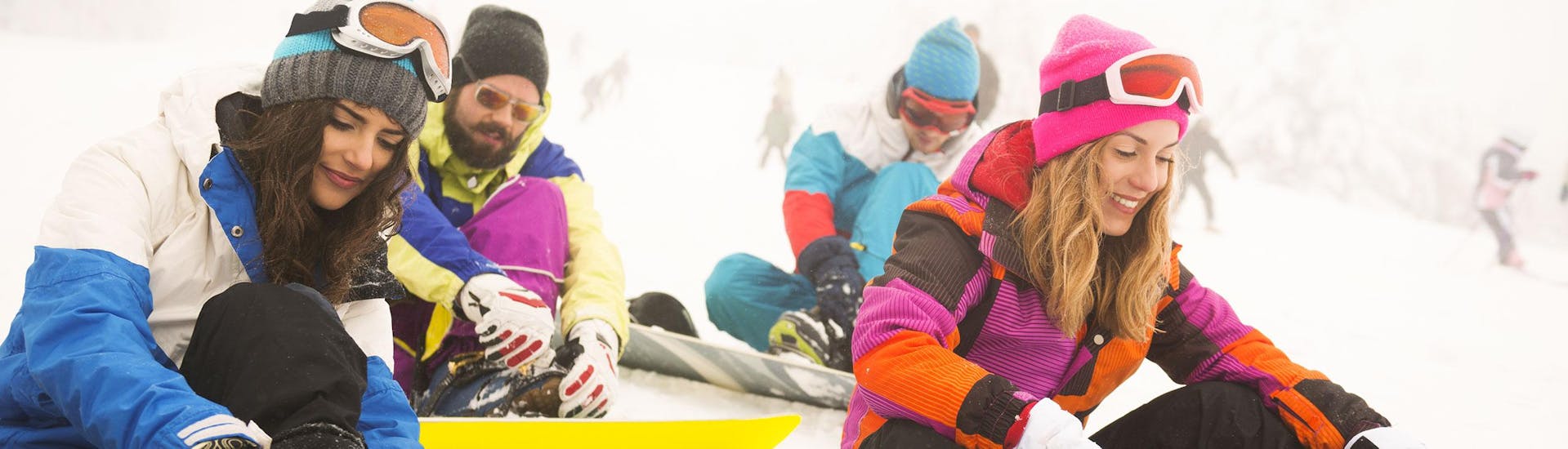A group of snowboarders strapping on their snowboards during one of the Snowboard Instructor Private - All Ages & Levels  organised by Independent Snowboard School.