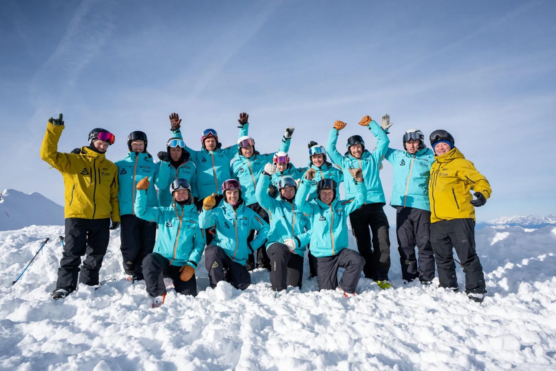 Das Team von Snowsports Kaprun posiert in Skianzügen für ein Foto auf der Piste.
