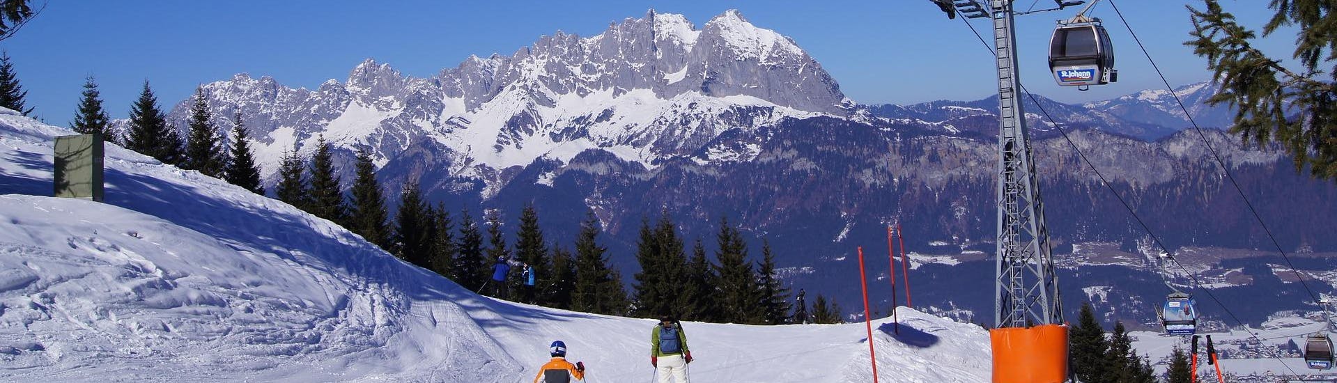 Adults and kids skiing in St Johann in Tirol ski resort.