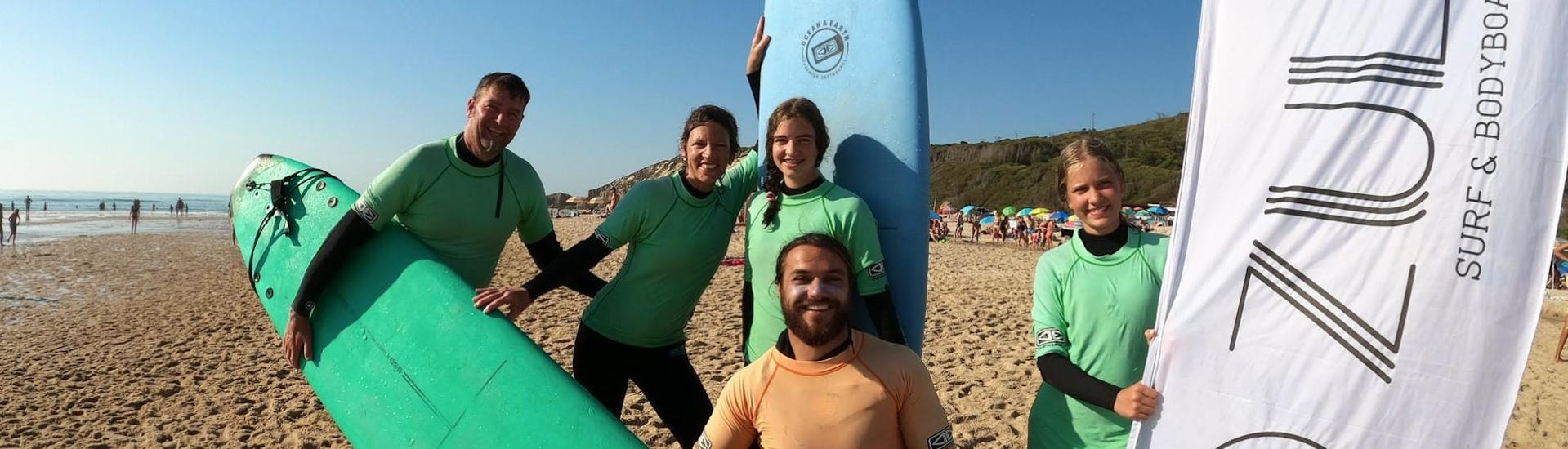 A group of people on the beach smiling and having fun during the Surf Lessons in Nazaré with Zulla Surf School Nazaré.