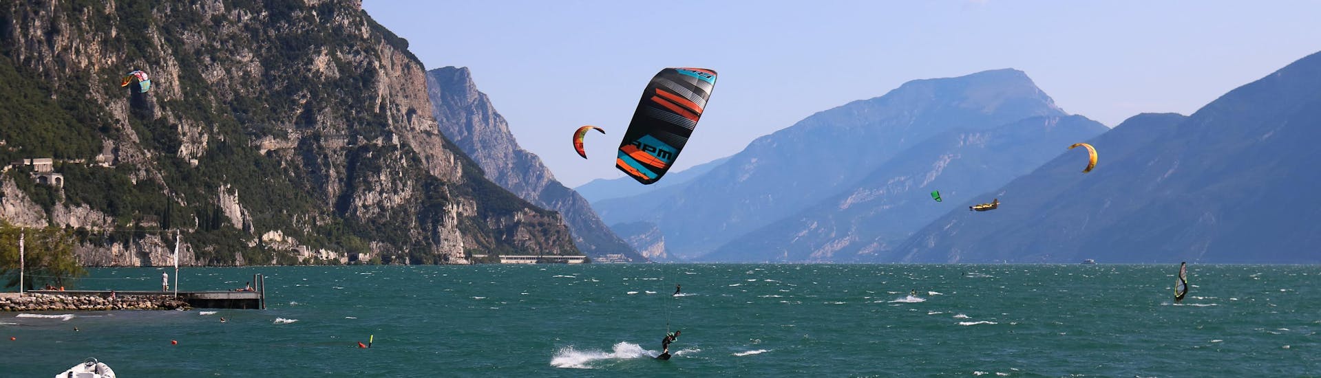 A young woman surfing in the clear blue waters of the surfing and SUP hotspot of Brenzone sul Garda.