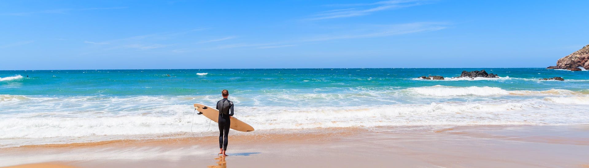 Una surfista sfida le onde facendo surf presso Albufeira.