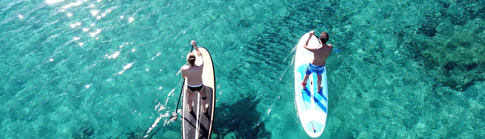Una surfista sfida le onde facendo surf presso Ibiza.