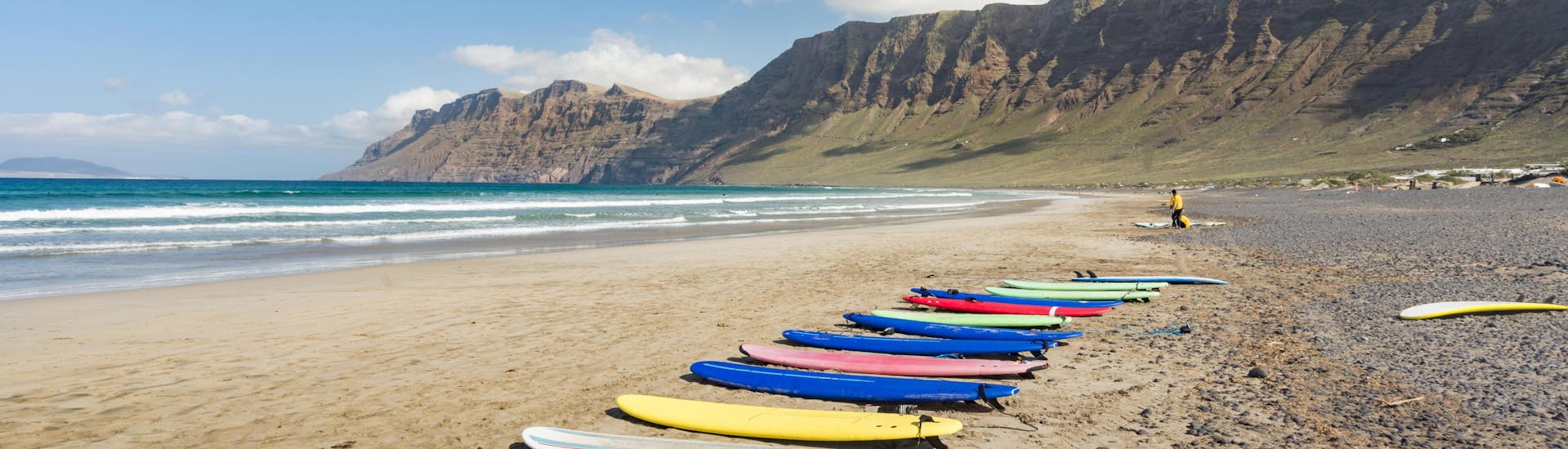 A set of surf boards is lined up on the beach for people to go surfing in Lanzarote.