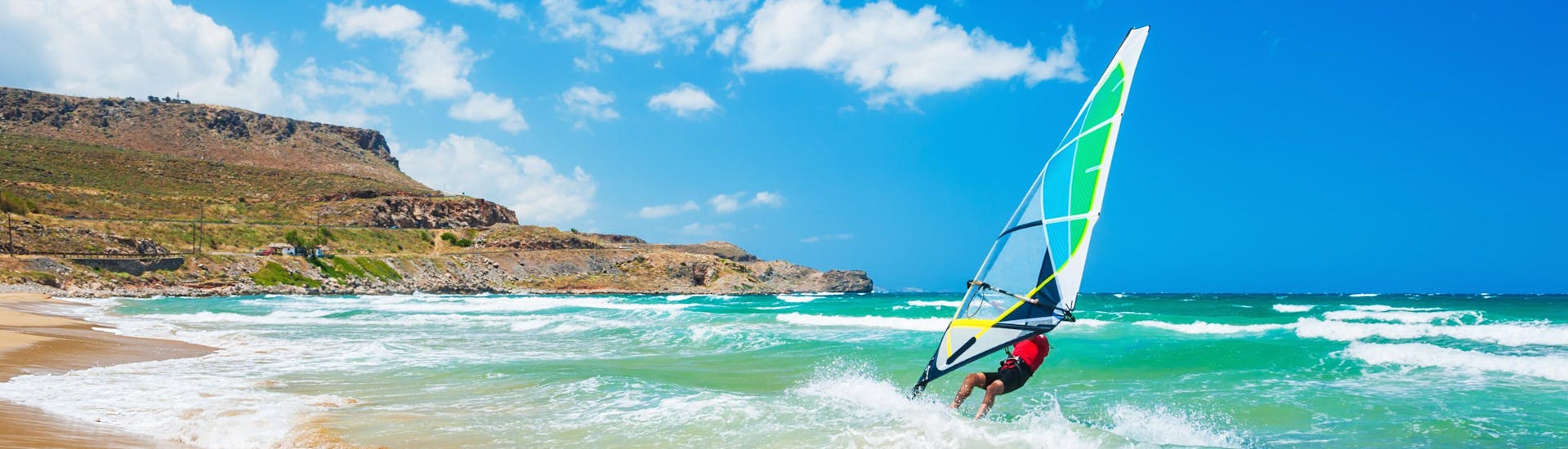 Une jeune femme fait du surf dans la destination de vacances Santorin.