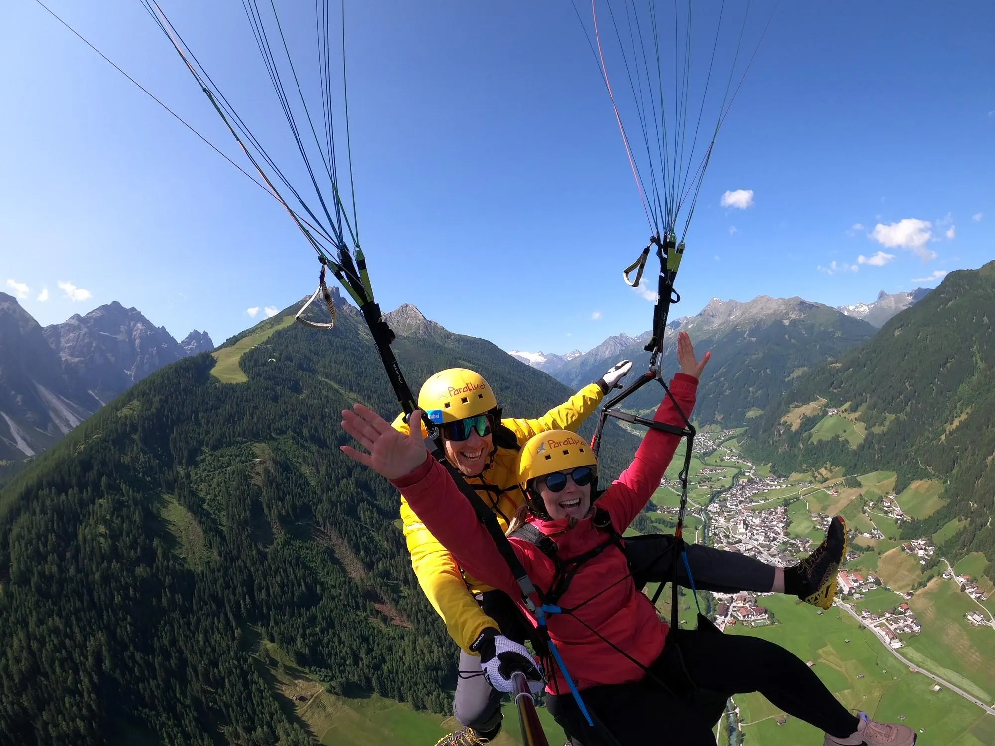 Tandembild Domi Elfer spaß junge Frau (2) (1) Beeindruckende Landschaften mit Bergen und Meer, wo Aktivitäten von Flugschule Parafly Stubaital stattfinden.