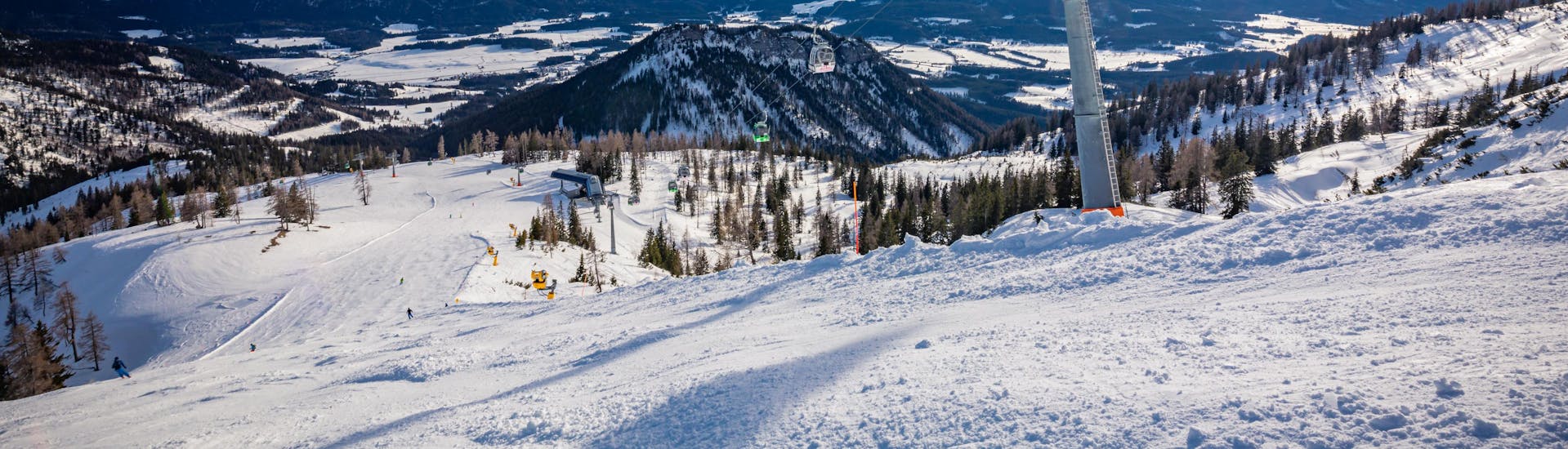 A view of a snowy mountain top in the ski resort of Tauplitz-Bad Mitterndorf, where ski schools gather to start their ski lessons.