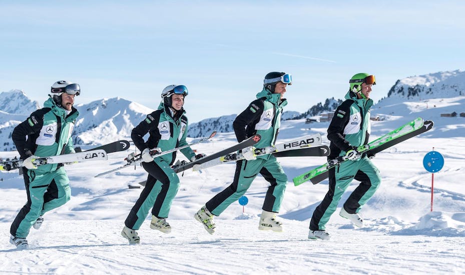Ski instructors from Skischool Schlern 3000 facing in one direction with their skis.