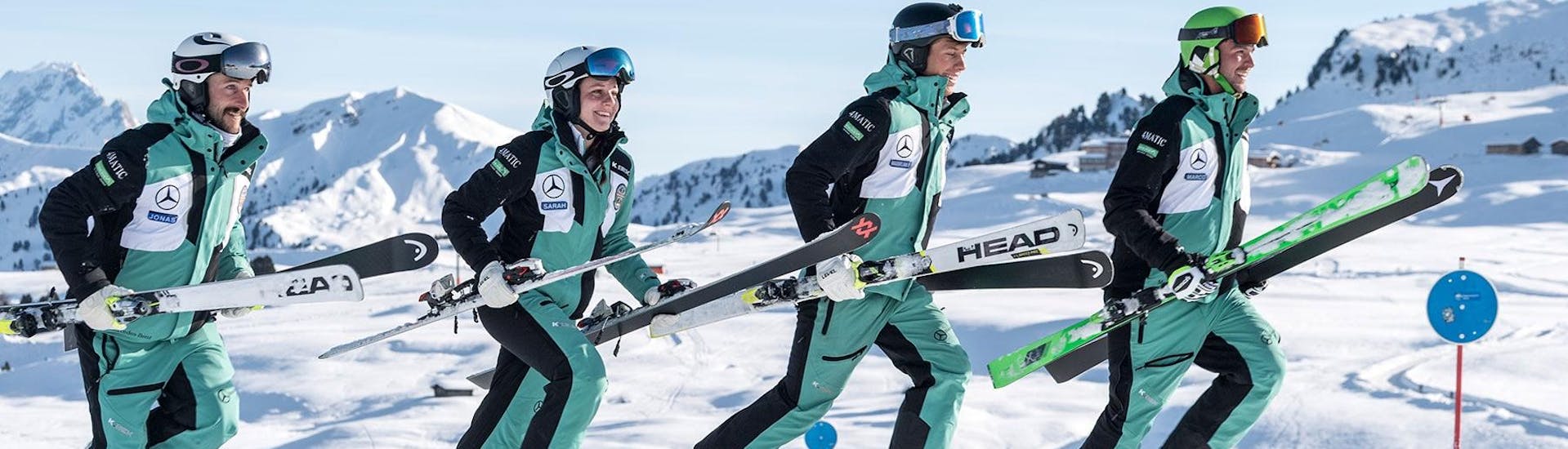 Ski instructors from Skischool Schlern 3000 facing in one direction with their skis.