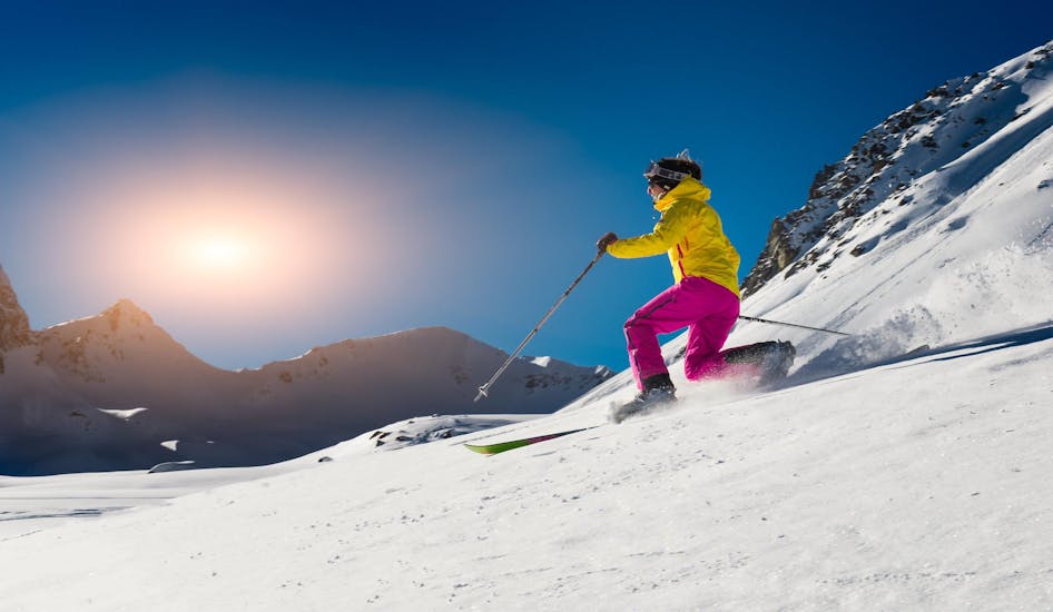 Sous un grand soleil, une skieuse glisse sur une piste de ski lors d'un Cours particulier de ski de fond organisé par ESI First Tracks Courchevel.