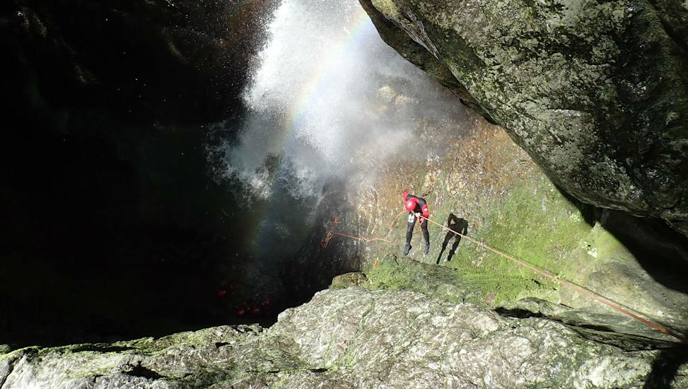 Un amateur de canyoning descend dans une gorge en rappel pendant une sortie canyoning organisée par Terréo Canyoning.