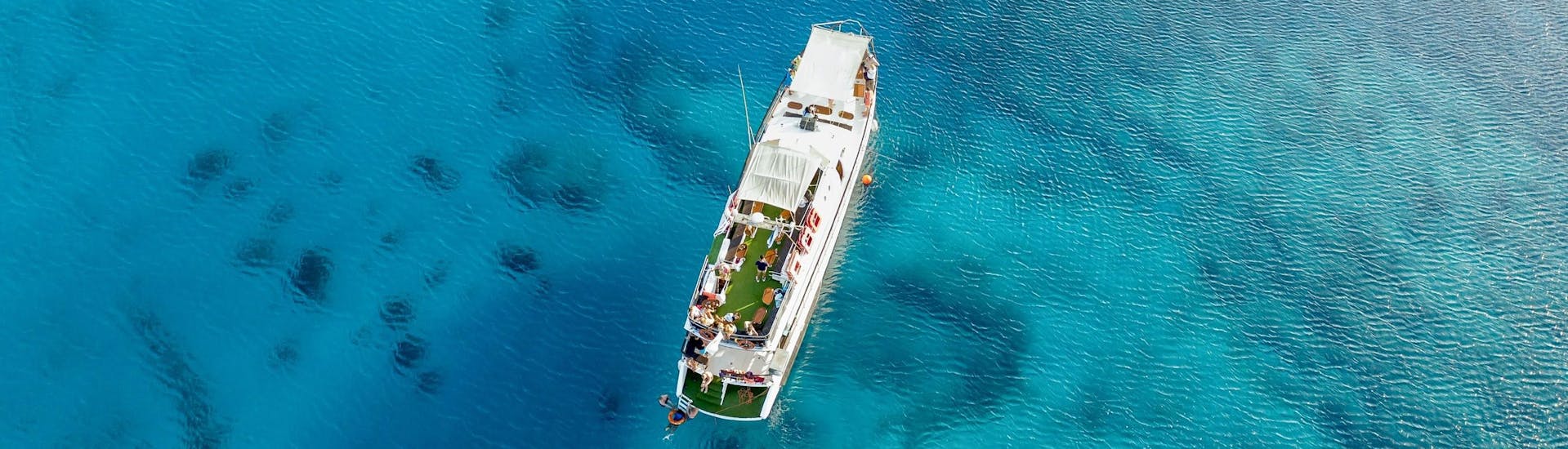 Boot von The Cyprus Cruise Company in klarem blauem Wasser.