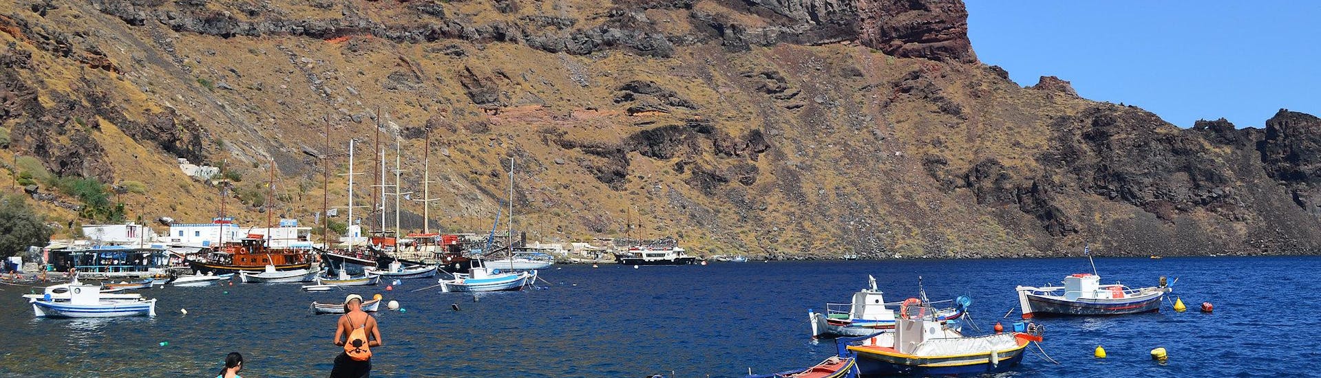 Varios barcos cerca de la costa durante un paseo en barco a la isla de Therasia.