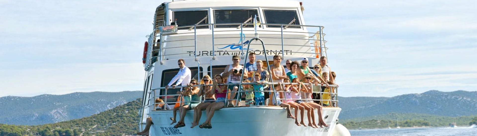 Menschen sitzen auf dem Boot während der Bootstour zum Nationalpark Kornati mit Tureta Tours Murter.